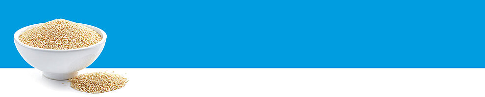 A white bowl filled with a granular substance sits on a white surface against a blue background.