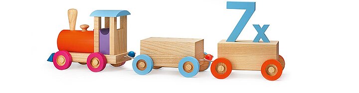 A wooden toy train with colorful wheels and a blue number 7x on a wooden block.