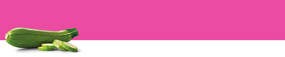 A zucchini with slices is presented against a pink and white background.