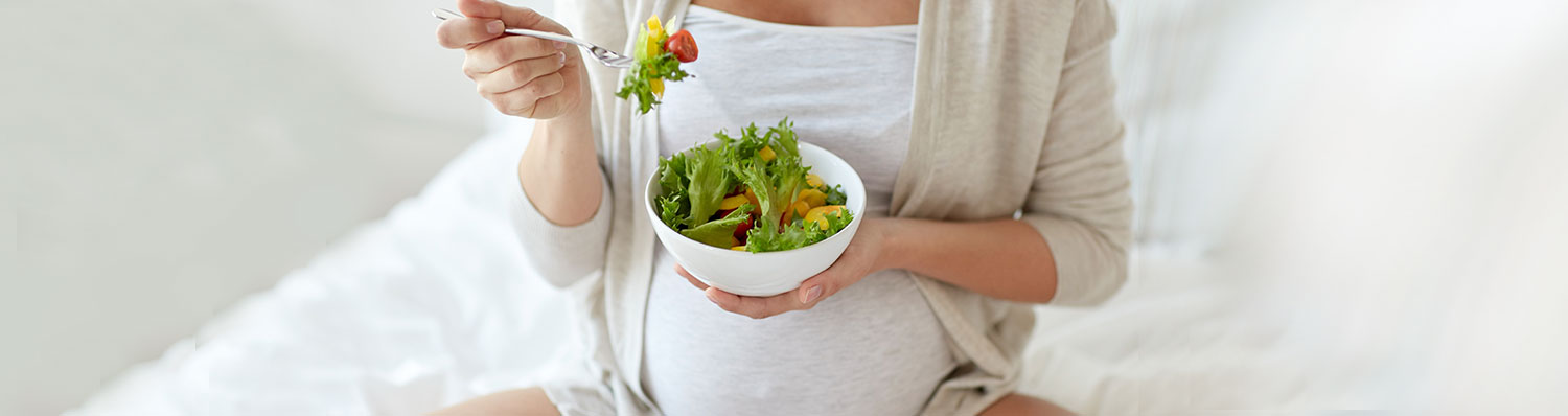 A person is eating a salad from a bowl.