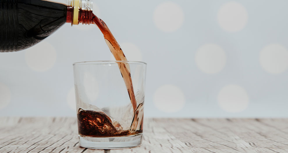A dark liquid is being poured into a glass.