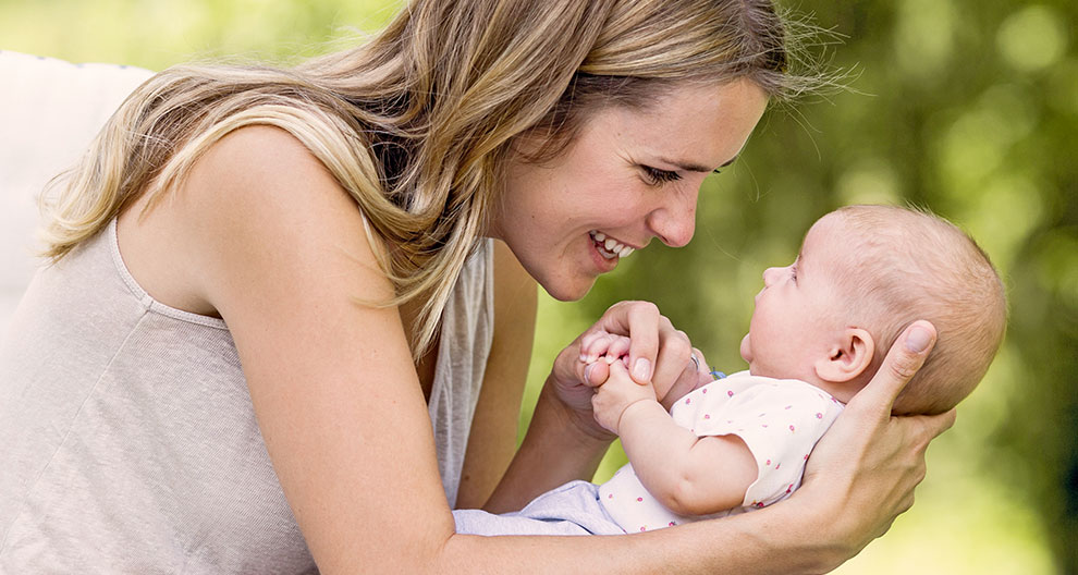 A woman lovingly holds a baby.