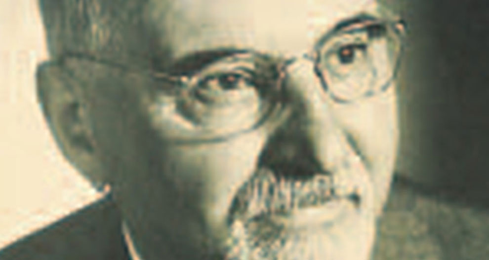 A close-up of a man's face, showing his eyes, nose, and mouth, with a beard and mustache, wearing glasses.